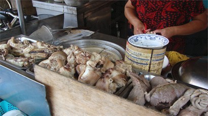 攤前滿滿的排著豬腳與各式豬的內臟，迎面撲來的是濃濃的四神湯味，夾雜著半熟的豬肉腥味。