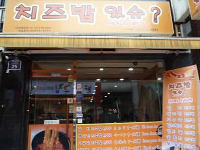 小店位於梨大購物街的橫街，店外的易拉架顯示芝士石鍋飯好吸引，而且標明4,000韓元，試試無妨。