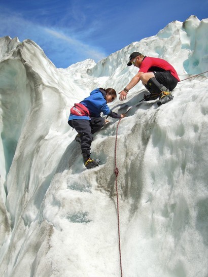 放下安全繩，邊引導團員安全的爬上大冰塊