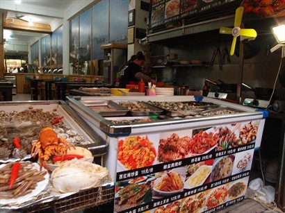 街上有好多以大排檔式經營嘅食店, 海鮮小菜一樣供應