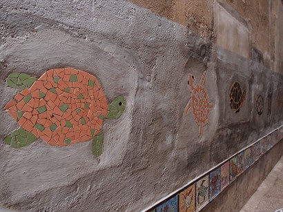 破舊的牆上, 砌了好多五顏六色嘅馬賽克海龜