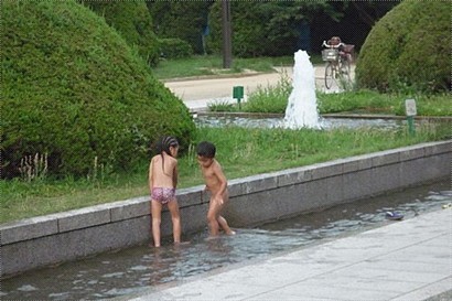 天氣很熱, 小朋友乾脆脫光衣服到水池玩水